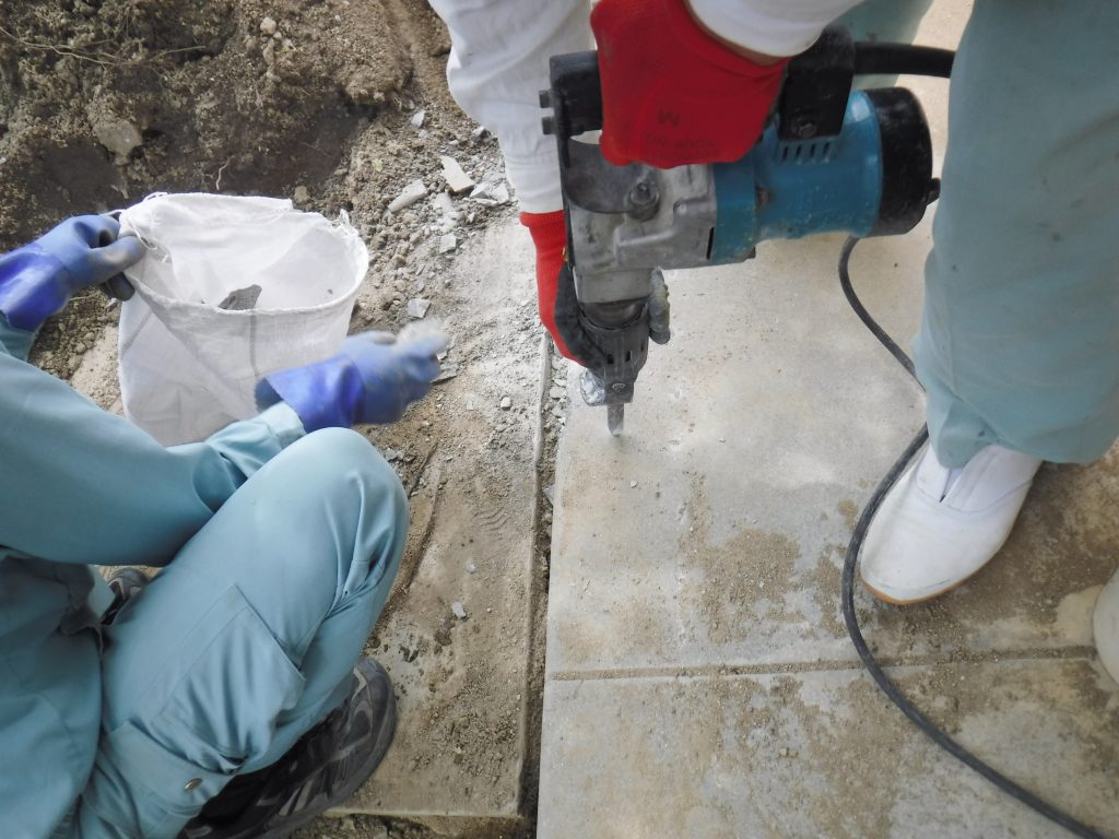 屋外の水道管に水道メーターを取り付けるためコンクリート掘削中