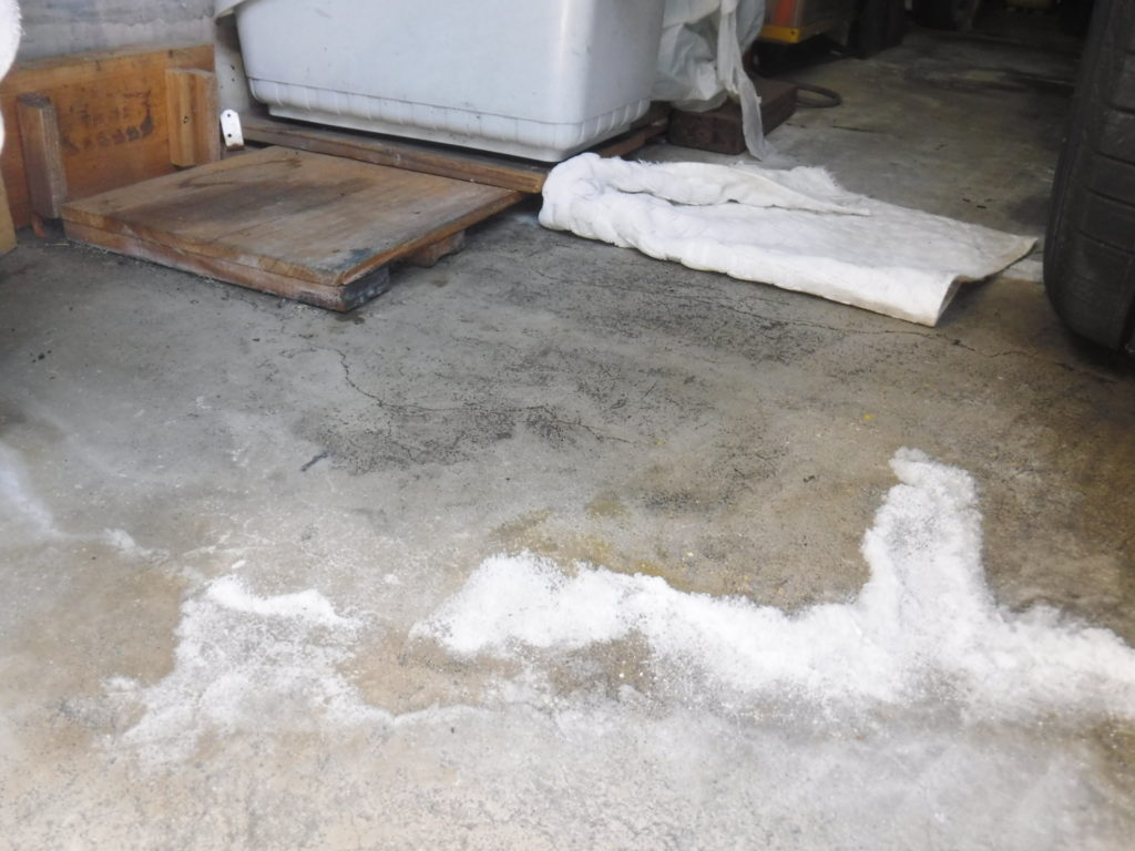 車庫ガレージのコンクリート床が濡れて塩のようなものが浮いています