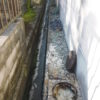 排水管が詰まり汚水が溢れて地面の側溝に逆流/高圧洗浄パイプクリーニング