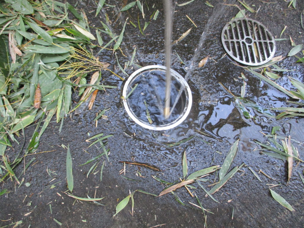 土間雨水管から高圧洗浄清掃作業中