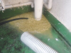 ベランダに溢れた汚水の回収、パイプの洗浄作業中
